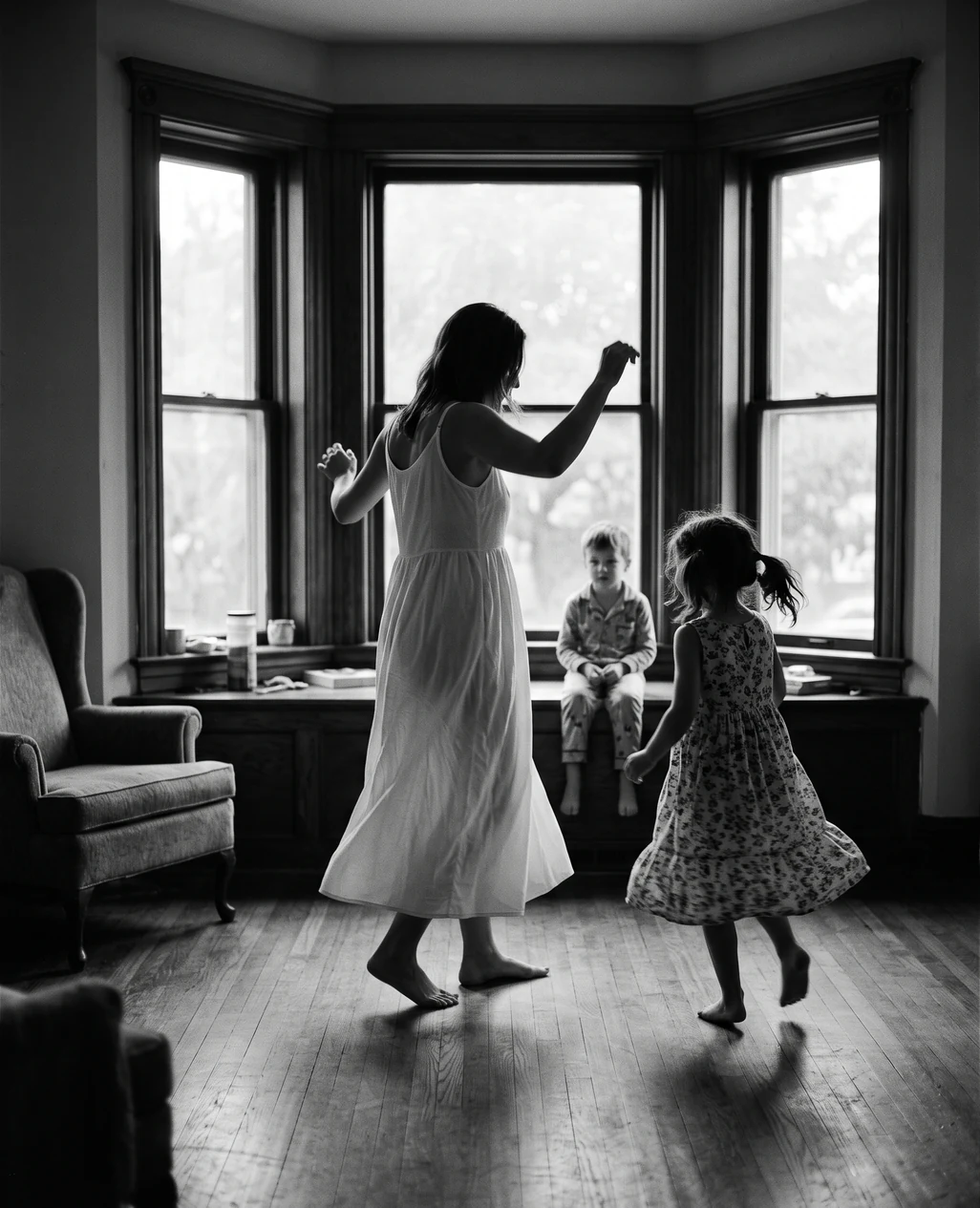 A mother and daughter dancing in a bay window